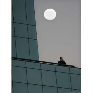  The Moon Rises as a Smoker Has a Cigarette on the Balcony 