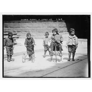  Children with tricycles,playing in street,New York