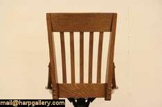 An authentic 1915 era swivel desk chair is solid quarter sawn oak 