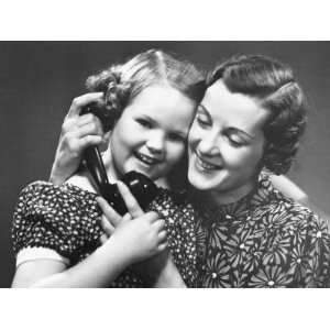 Mother Helping Daughter (6 7) Holding Phone Receiver Photographic 